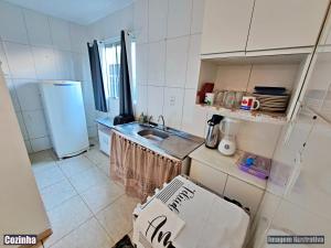 a small kitchen with a sink and a refrigerator at CASA DE VERANEIO PERUIBE in Peruíbe