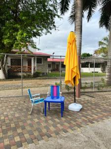a umbrella and two chairs and a table and a blue chair at Cabaña Cangrejito Olon in Olón