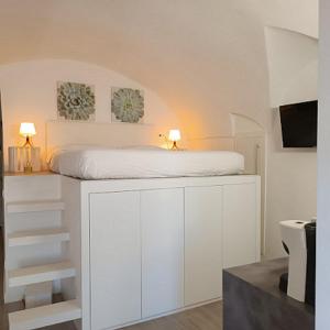 Un dormitorio con una cama blanca con dos lámparas. en Giulietta Central Loft, en San Remo