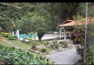 um jardim com uma casa e uma piscina em Pousada Estação Boca do Mato em Cachoeiras de Macacu