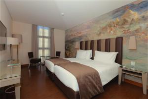 Un dormitorio con una cama grande con un cuadro en la pared. en Vila Galé Paulista, en São Paulo 26 fotos más