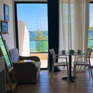 a living room with a table and a couch and a window at comfort rooms in Himare