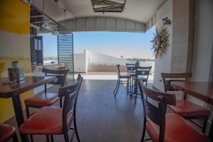 Hotel Villa Express Durango في ولاية دورانغو: غرفة طعام مع طاولات وكراسي في مطعم