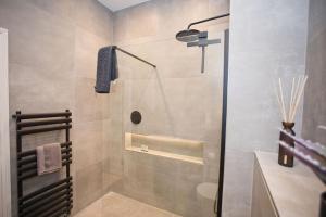 y baño con ducha, aseo y lavamanos. en Ultra Stylish Apt set in an affluent location, en Poole