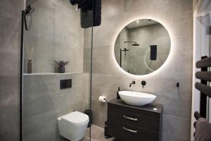 a bathroom with a toilet and a sink and a mirror at Ultra Stylish Apt set in an affluent location in Poole