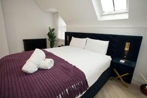 un dormitorio con una cama con un animal de peluche en Ultra Stylish Apt set in an affluent location, en Poole