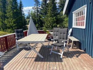 una mesa de picnic y 2 sillas en una terraza en Hytte til leie på Budor, en Nordset