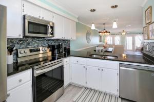 Cape San BlasにあるEdgewater Retreat by Pristine Properties Vacation Rentalsの白いキャビネットとステンレス製の電化製品を備えたキッチン +77枚の写真
