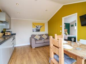 a kitchen and living room with a table and a couch at Maple in Swadlincote