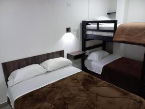 um quarto com 2 camas e um beliche em El Vergel Norte em Quito