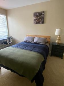 Un dormitorio con una cama grande y una mesa con una lámpara. en CHIC & Cozy 1bd/1ba in MDR w/ pool/gym/parking, en Los Ángeles