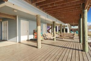 un porche de una casa con terraza de madera en Holiday House A by Pristine Properties Vacation Rentals, en Mexico Beach