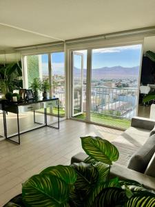a living room with a couch and a table and windows at Céntrico y vista insuperable in Calama