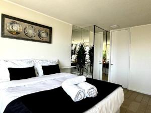 a bedroom with a large bed with towels on it at Céntrico y vista insuperable in Calama