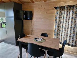 a dining room table with chairs and a refrigerator at Chalet Edelweis in Plombières-les-Bains +3 photos