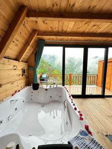 a bath tub in a room with a large window at Northland Bungalows in Çayırdüzü