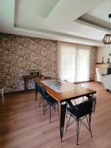 Zeni Villa - Fırtına Deresinde mükemmel konaklama في ريزي: غرفة طعام مع طاولة وكراسي خشبية