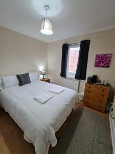 ein Schlafzimmer mit einem großen weißen Bett und einem Fenster in der Unterkunft Arthur St Rooms in Edinburgh