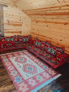 sala de estar con sofá rojo y alfombra en Zeni Villa - Fırtına Deresinde mükemmel konaklama, en Rize