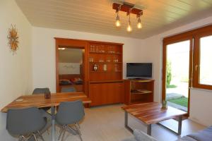 a living room with a wooden table and a television at Carpediem Apartments in Schönwald