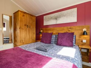 een slaapkamer met een groot bed met paarse kussens bij Oak in Swadlincote