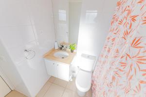 a bathroom with a toilet and a sink and a shower curtain at Céntrico y vista insuperable in Calama