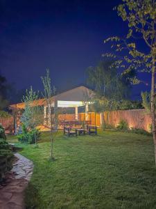 a backyard with a picnic table and a fence at The Rose Farm, mini parties, accommodation, pool, playground, bbq in Ciolpani
