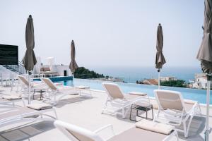 een patio met witte stoelen en een zwembad bij Padam Hotel & SPA in Ulcinj