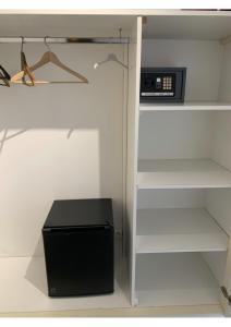 um armário com um frigorífico preto e um micro-ondas em Malocco em Pontcarré