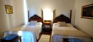 um pequeno quarto com duas camas e uma mesa em Finca El Recreo em Cafayate