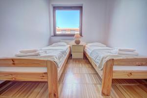 2 camas individuais num quarto com uma janela em HelApart - Helska Villa em Hel