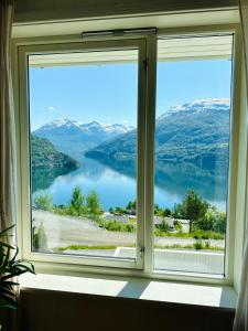 una ventana con vistas a una masa de agua en Leilighet med fantastisk utsikt, en Stryn