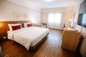 a hotel room with a large bed and a window at Comfort Suites Londrina in Londrina