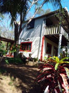 una casa a strisce rosse e bianche di Jungle Vacation Home with river and waterfall. a Santa Rita