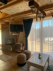 a living room with a table and some windows at Etna planinska kuca in Bajina Bašta