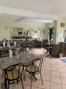 a dining room with tables and chairs and a kitchen at chez stephane in Pontcarré