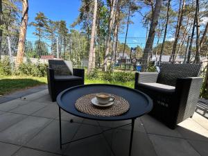 - une table avec une tasse de café sur la terrasse dans l'établissement DOMKI BURSZTYN, à Mrzeżyno