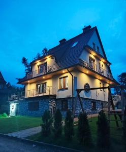a house with lights on the side of it at Willa Hajnówka in Zakopane