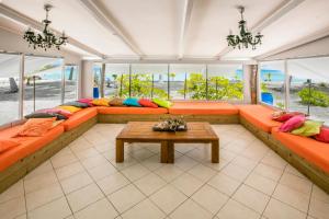 a living room with orange couches and a table at Fafarua Ile Privée Private Island in Tikehau