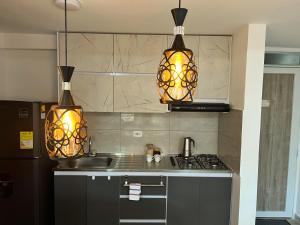 een keuken met twee hanglampen boven een fornuis bij Apartamento nuevo contiguo a estación de buses in Manizales