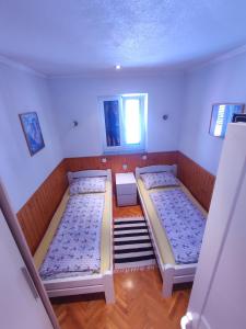 two beds in a room with two windows at M&R apartmani Rovinj in Rovinj