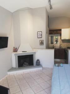 a living room with a fireplace in a kitchen at SPYROS STONE house in Preveza