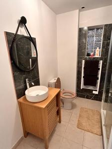 Un baño con lavabo, inodoro y ducha. en Bel appartement, en Les Mureaux