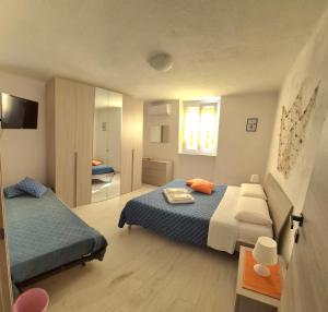 a small bedroom with two beds and a television at Casa Vacanze Matilde in La Spezia