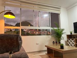 un soggiorno con divano e una grande finestra di Apartamento nuevo contiguo a estación de buses a Manizales