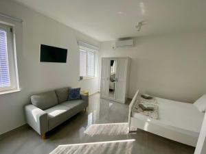 uma sala de estar com um sofá e uma televisão em Apartments Dolores em Senj