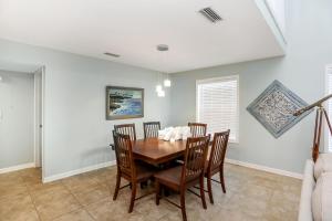 a dining room with a wooden table and chairs at Sharkey's by Pristine Properties Vacation Rentals in Cape San Blas +37 photos