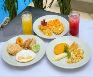 three plates of breakfast food on a table with drinks at Hotel El Marqués De Manga in Cartagena de Indias