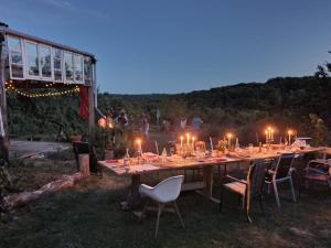 a long table with candles and chairs in the grass at Le petit Permadise in Chassiecq