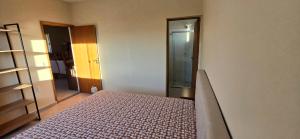 una camera da letto con un letto in una stanza con uno specchio di Apartamento mobiliado com vista da linda Serra Mantiqueira a Cruzeiro Altre 6 foto